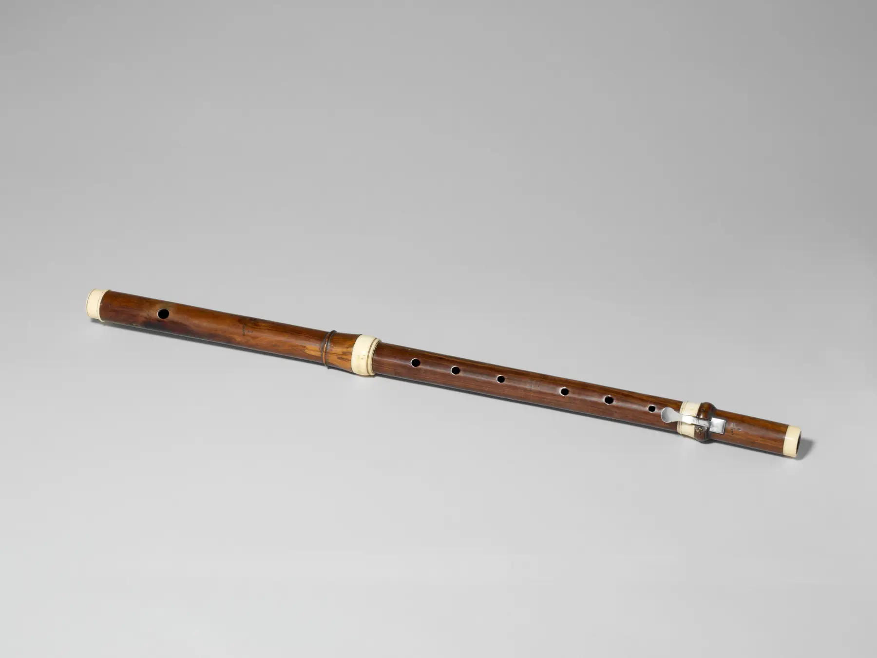 A rosewood transverse flute with ivory and silver parts